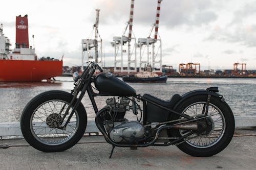 Retro motorbike in river port against ships