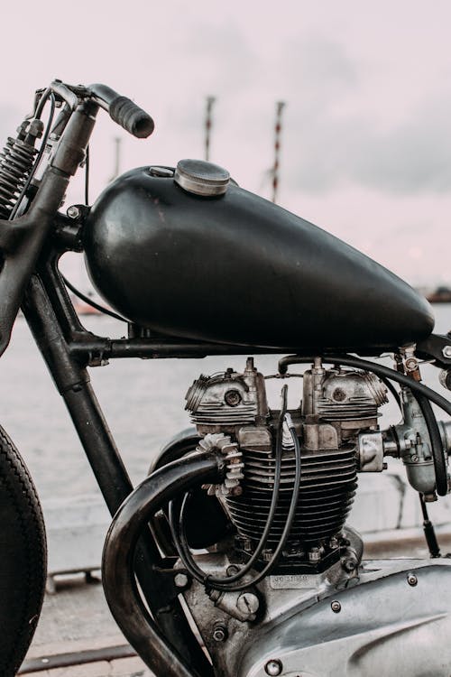 Motorbike with gas tank and iron engine on river bank