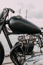 Motorbike with gas tank and iron engine on river bank