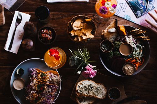 Free From above of tasty tacos near glass of refreshing drinks and vegetable slices with sauces in cafe Stock Photo