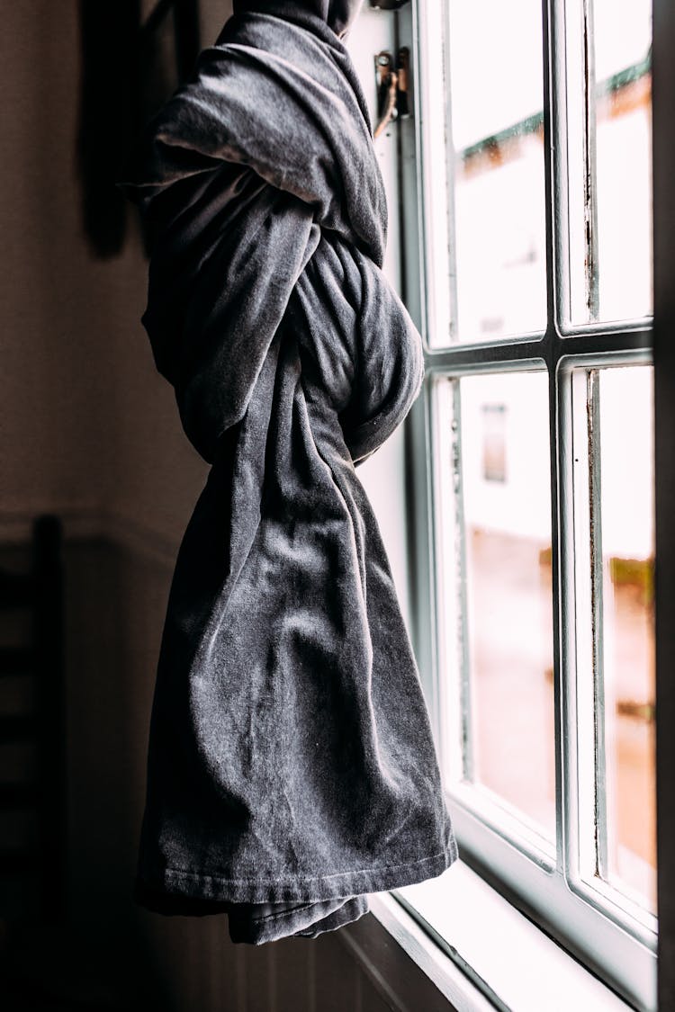 Grey Curtain Tied In Knot Hanging Near Wooden Window In Light House