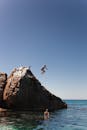 一个惊心动魄的时刻，一个人的悬崖跳入大海在一个阳光明媚的日子，捕捉自由和冒险