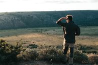 Unrecognizable traveler standing on hilltop in daytime