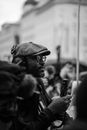 Black and white side view of African American male correspondent in eyeglasses and headphones with microphone during demonstration in city