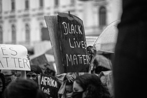 Free Black and white of anonymous demonstrators with cardboard placards during activist movement fighting for social justice and equality on street Stock Photo