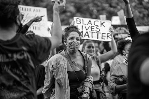 Black and white of demonstrators showing cardboard placards with Black Lives Matter title during strike in town