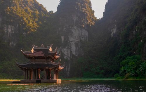 Free A tranquil pagoda on a lake surrounded by lush mountains in Ninh Bình, Vietnam. Stock Photo