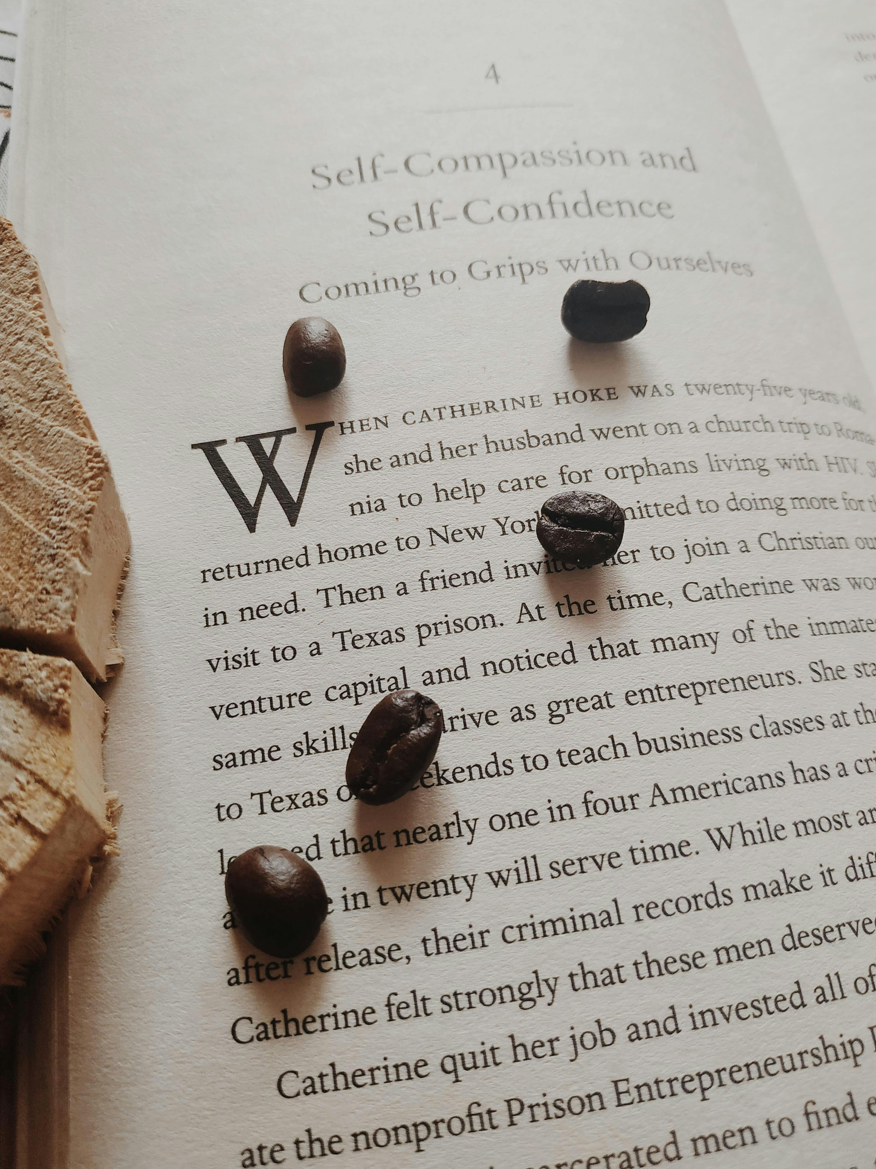 Close-up of coffee beans scattered on an open book page, highlighting text and texture.
