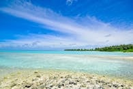 马尔代夫拉穆环礁的热带海景宁静怡人，拥有清澈的蓝色海水、洁白的云层和郁郁葱葱的绿色植物