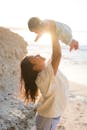 Woman Raising Baby up on Beach