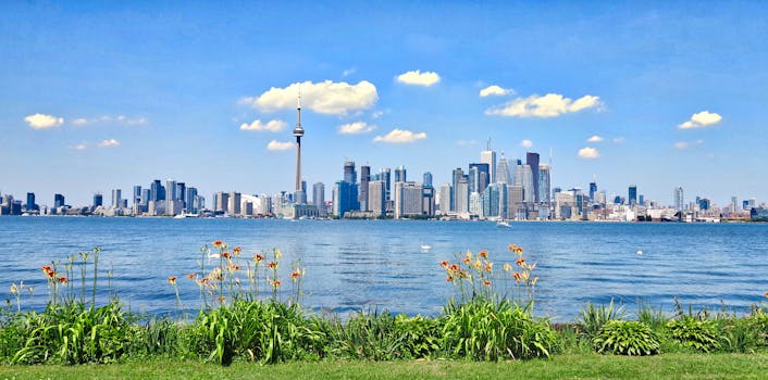 Scenic view of Toronto skyline with CN Tower against a clear blue sky, seen from across the waterfront.
