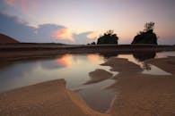 宁静的海滩上，沙滩悬崖与日落倒影共同捕捉了大自然的静谧