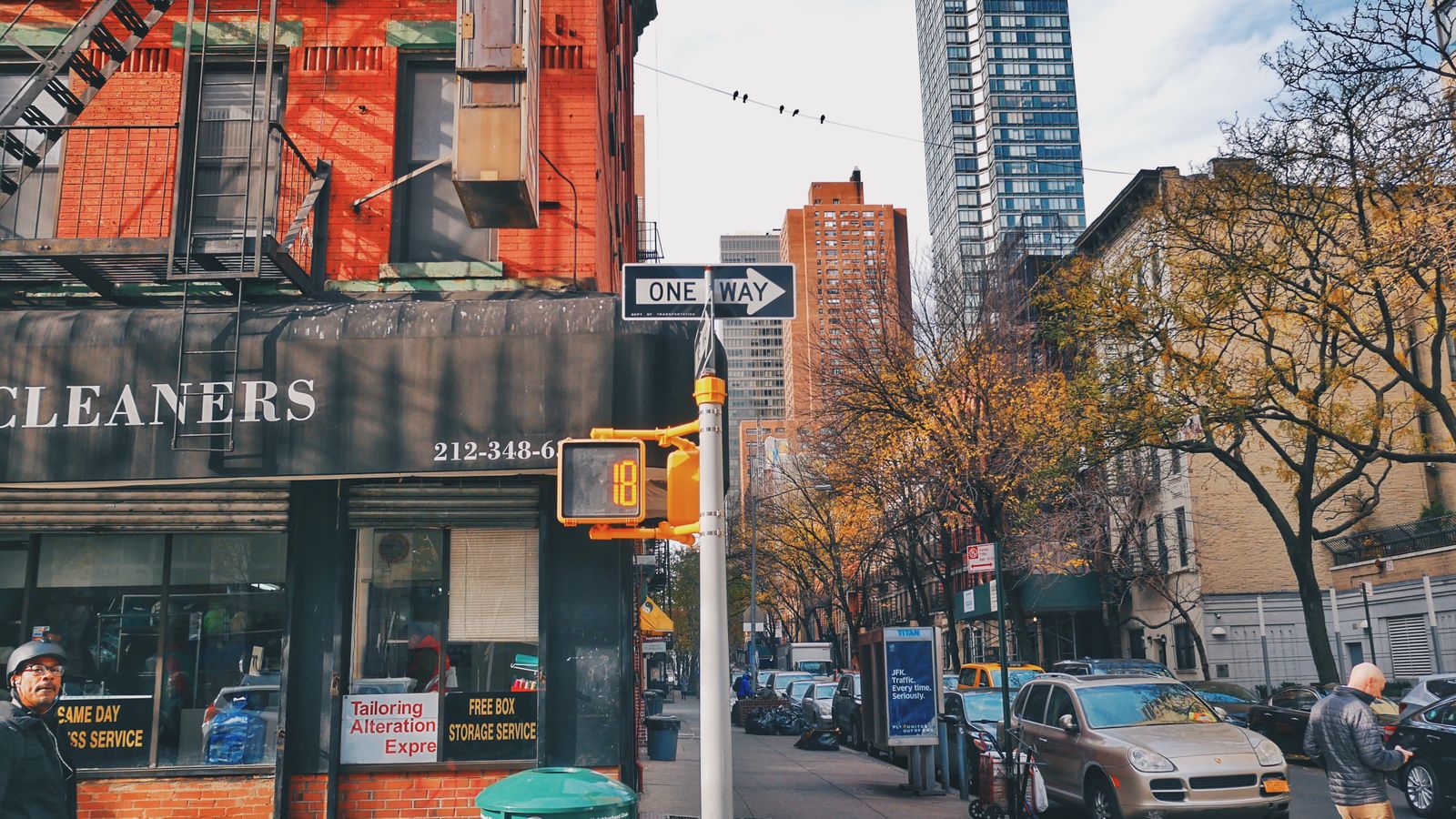 Urban street view featuring buildings, trees, and bustling activity in New York City.