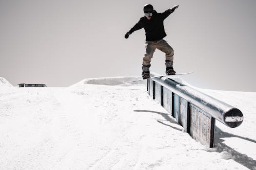 Dynamic snowboarder executing a rail trick on a snowy slope in Winter Park, Colorado.