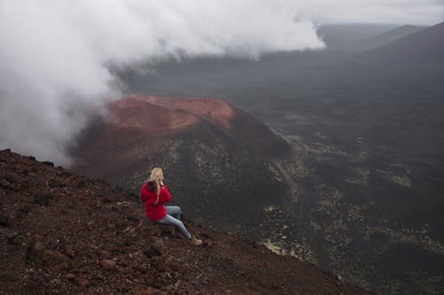 A Woman Sitting on Brown Rock 