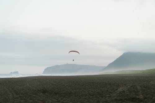 Free Parachuting over Sea Shore Stock Photo