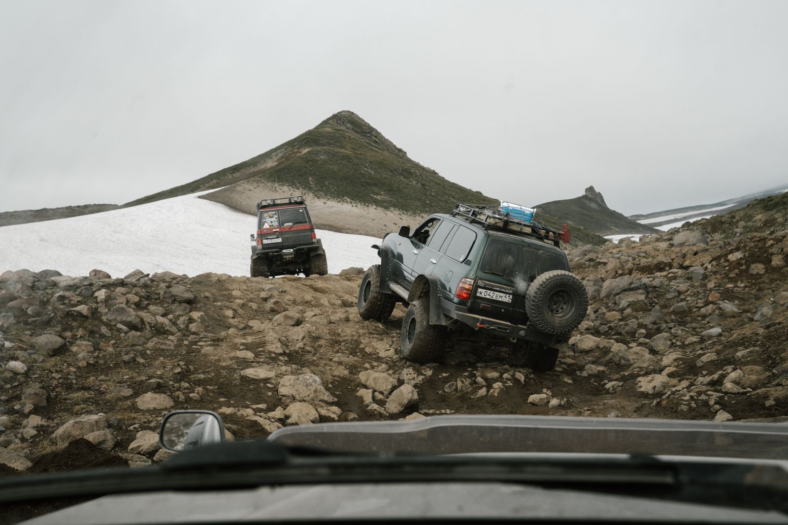 Off-road vehicle climbing rocky desert trail with aired-down tires gripping the rocks