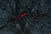 Person in Black Hiking Shoes Standing on Black Rock
