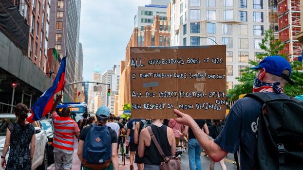 在城市街道上，人们举着标语游行抗议