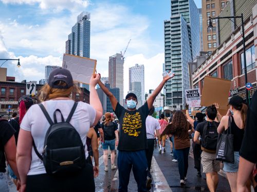 Free Demonstrators march through New York City streets holding placards during a peaceful protest. Stock Photo
