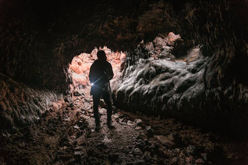 Free Person Exploring Cave Stock Photo