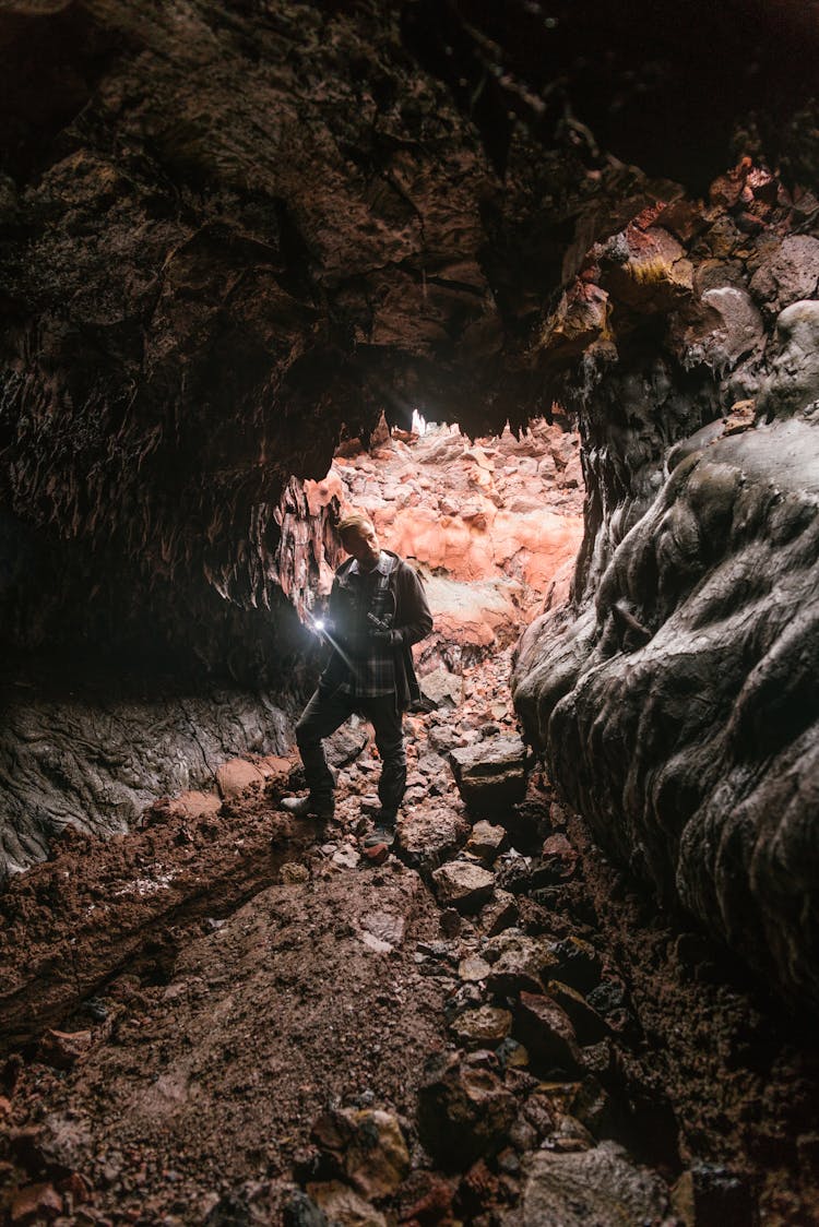 Man With Light Exploring Cave