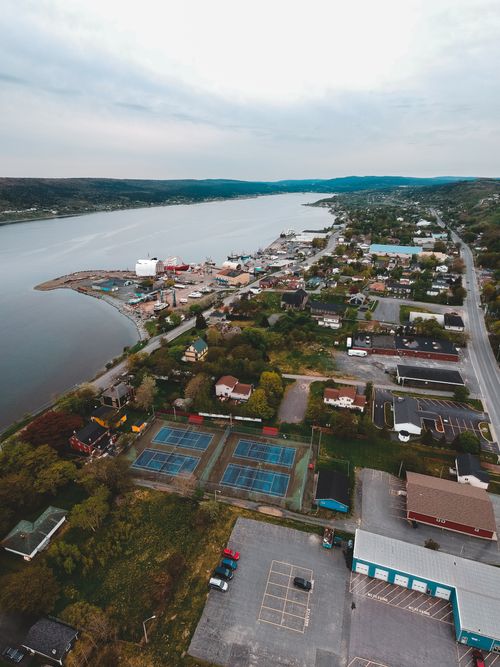 Free Aerial view of town with well developed infrastructure located on shore of river against cloudy sky Stock Photo