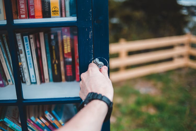 Crop Person Opening Public Bookcase In Park