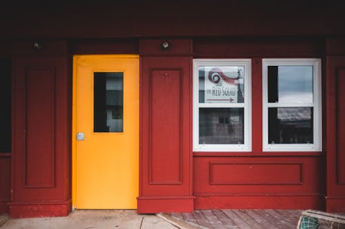 Exterior of cafe with red walls and yellow door