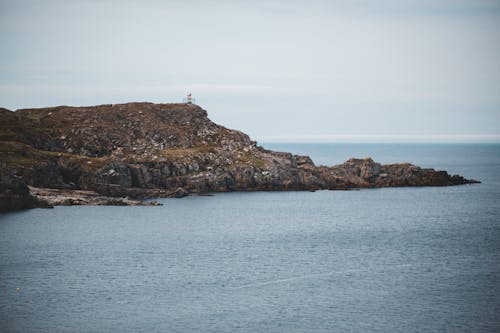 Free Remote lighthouse located on rocky seashore Stock Photo