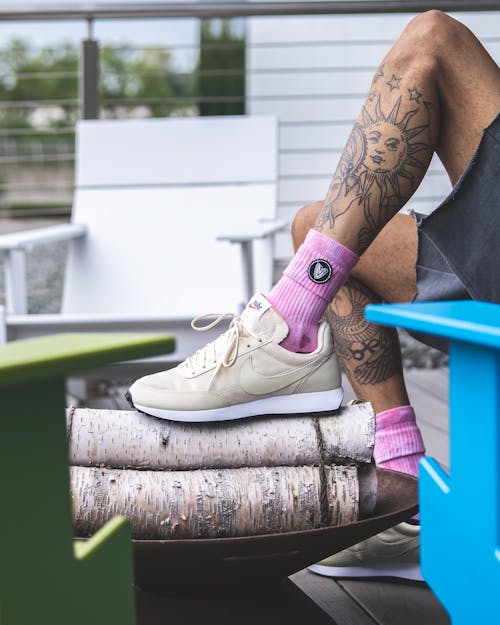 Crop tattooed man resting on veranda