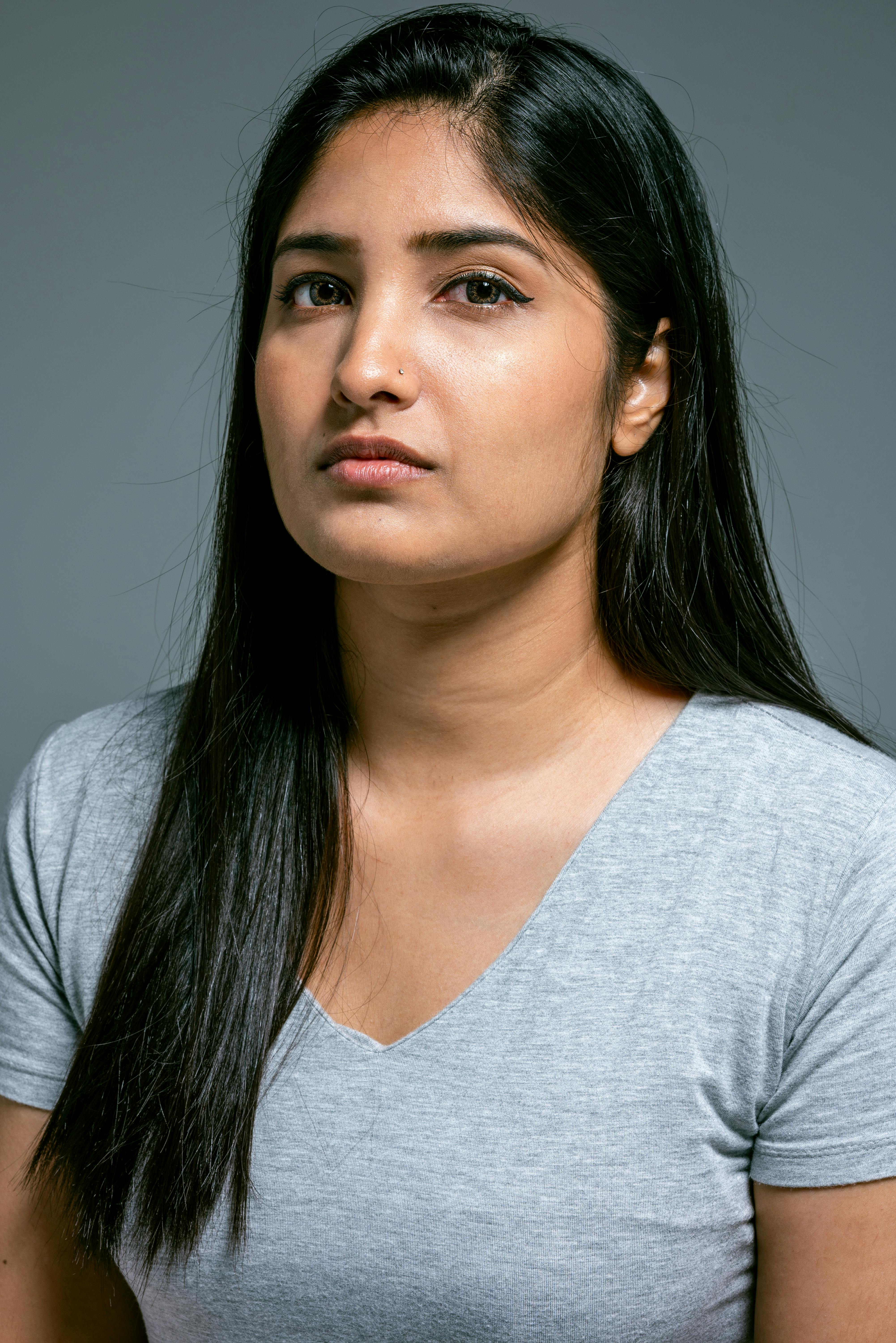Close-up portrait of a woman with long black hair in a studio setting.