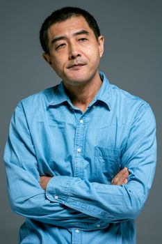 一个穿着蓝色牛仔衬衫的男人，神情深思，若有所思
