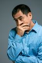 一位穿着蓝色牛仔衬衫、神情深思熟虑的男人的肖像