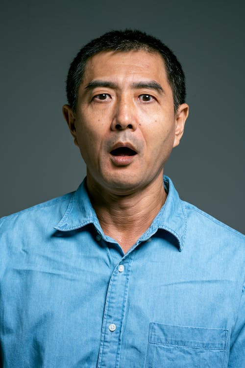 Man in Blue Button Up Shirt with Mouth Open