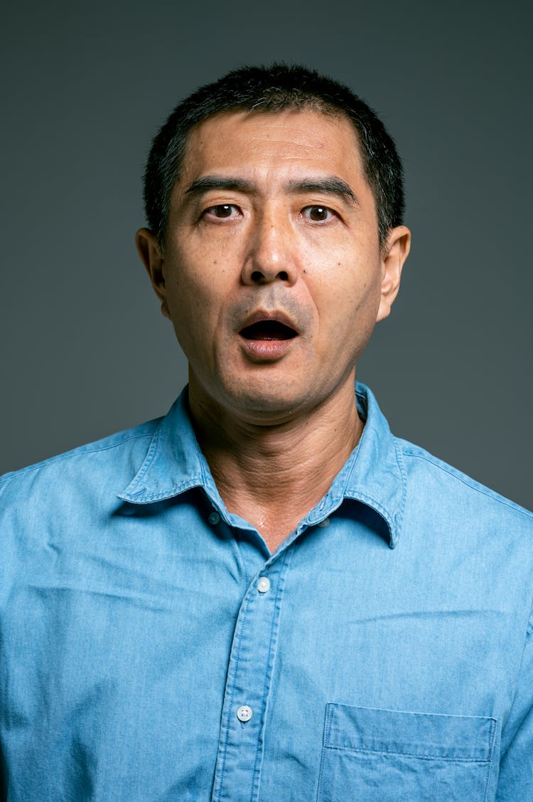 Man In Blue Button Up Shirt With Mouth Open