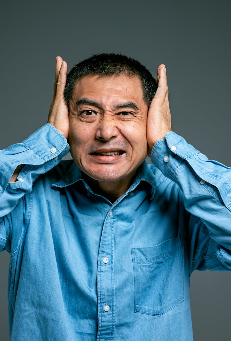 Man In Blue Button Up Shirt With Irritated Facial Expression