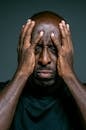 一名陷入困境的男子双手掩面，特写肖像传达出压力与情感