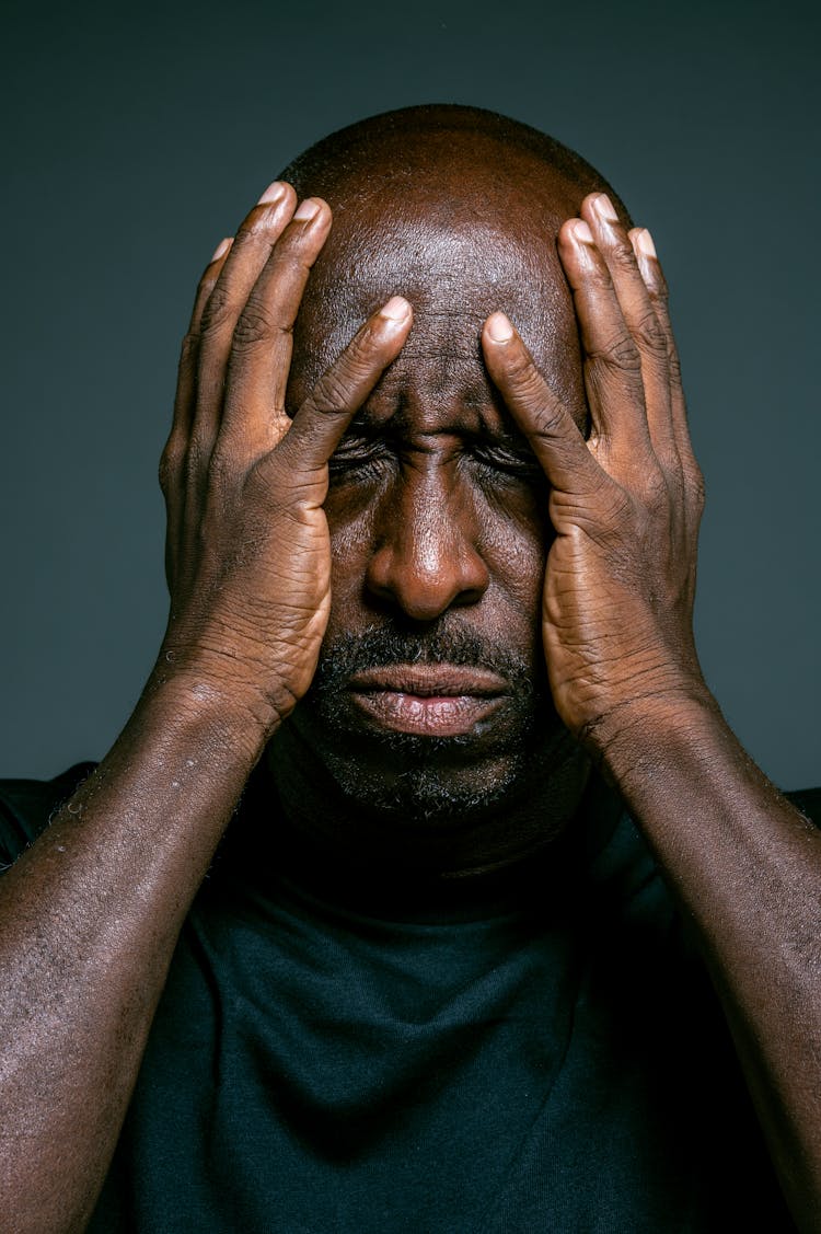 Man In Black Crew Neck Shirt Covering His Face