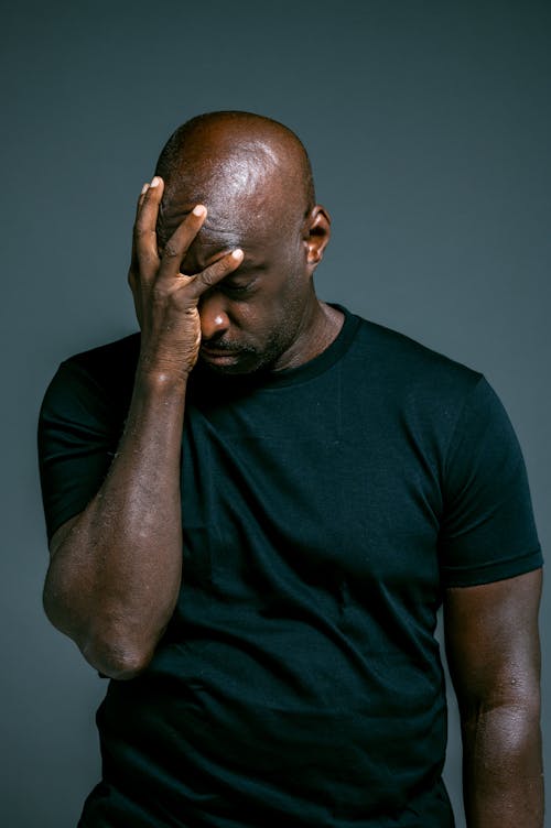 Man in Black Crew Neck T-shirt Covering His Face