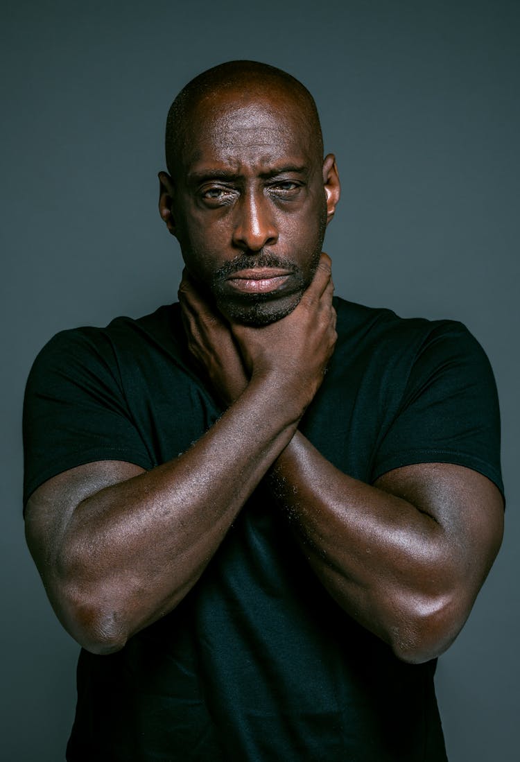 A Man In Black Crew Neck T-shirt With Hands On Neck