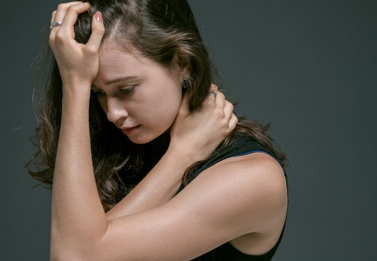 Woman Holding Hair With Hand On Forehead