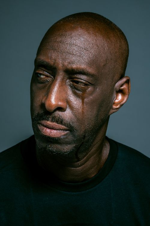 Free Close-up portrait of a serious bald man with teardrop, depicting deep emotion and thoughtfulness. Stock Photo
