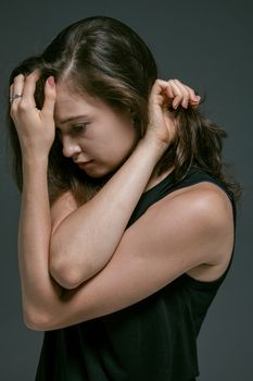 镜头特写一个女人，她把手放在额头上，显得深思而内省