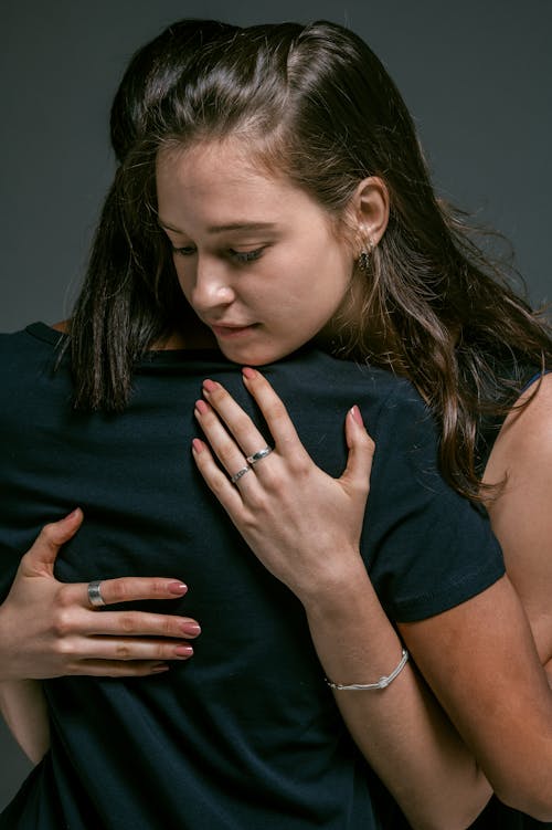 Free A Woman Hugging a Person in Black Top Stock Photo