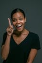 Woman in Black V Neck T-shirt Showing Her Pointing Finger