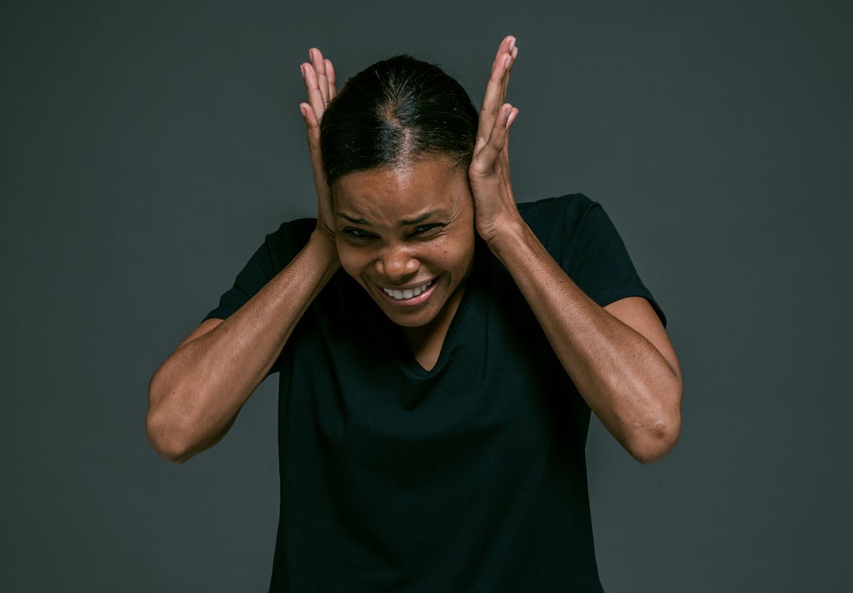 Person experiencing sensory overload in overwhelming environment