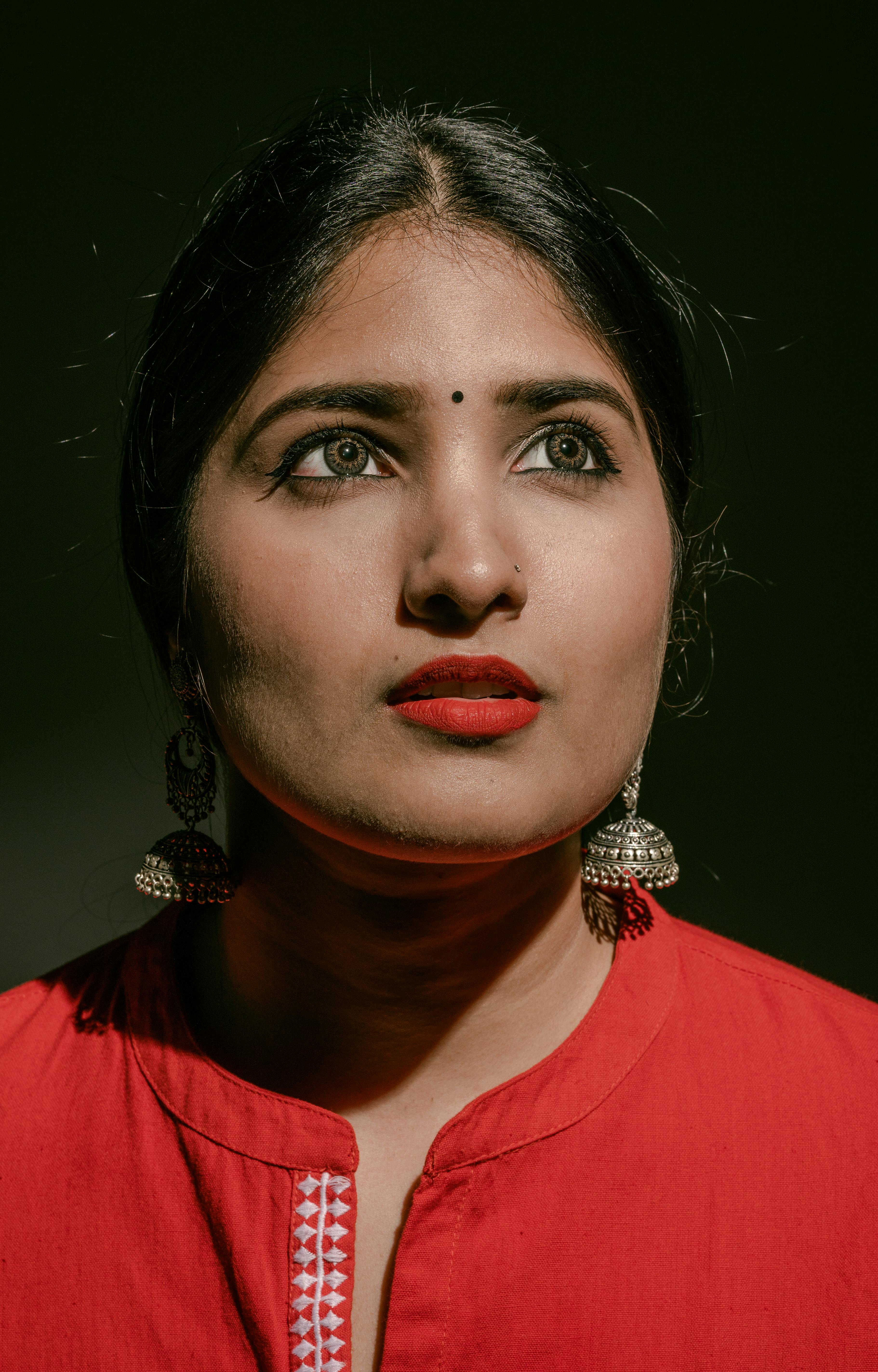 Portrait of a woman in red with silver earrings, showcasing beauty and elegance.