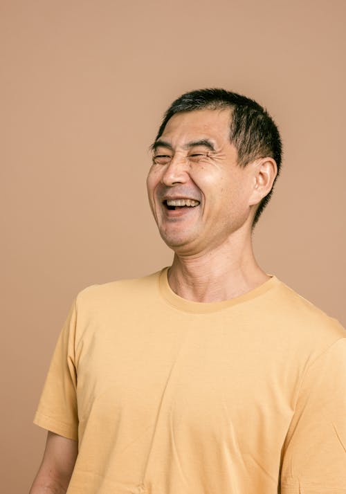 Gratis stockfoto met Aziatisch, blij gezicht, bruine achtergrond