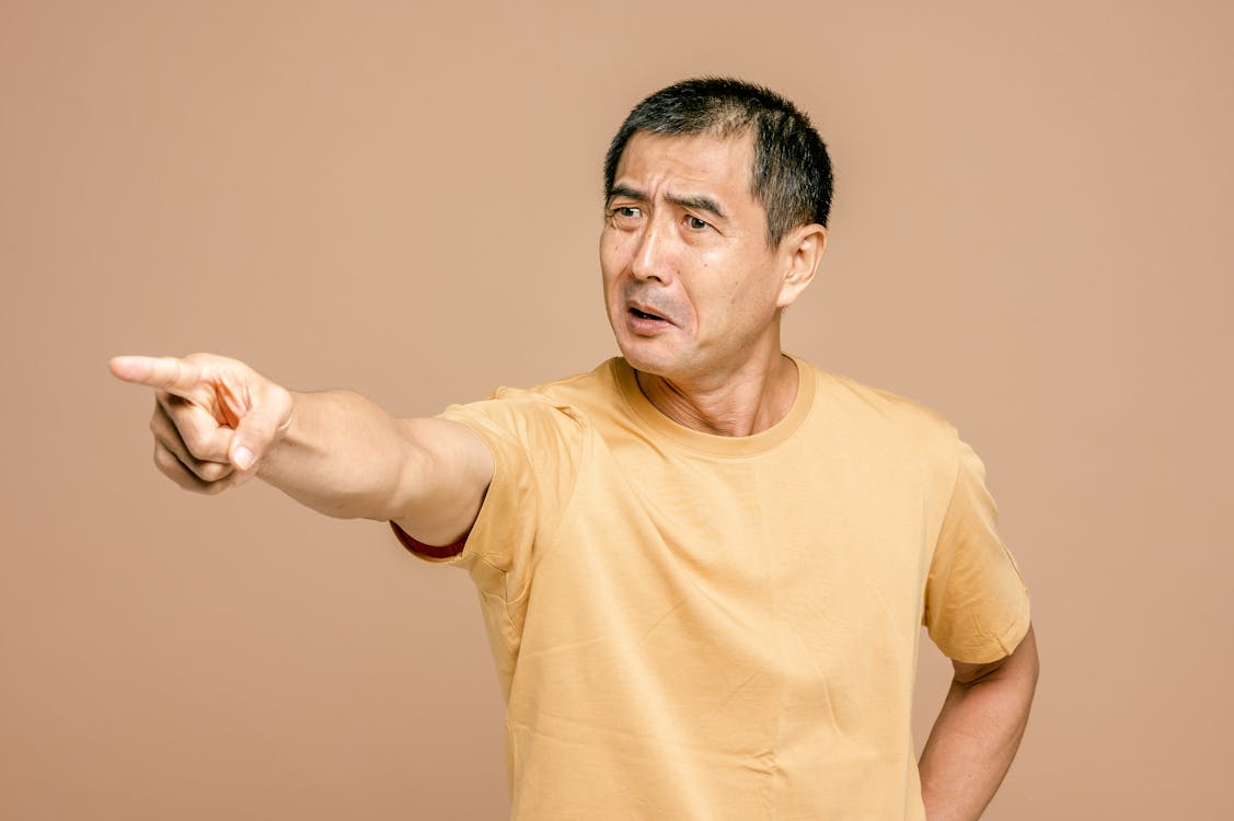 Free Man in Yellow Crew Neck T-shirt Pointing a Finger Stock Photo